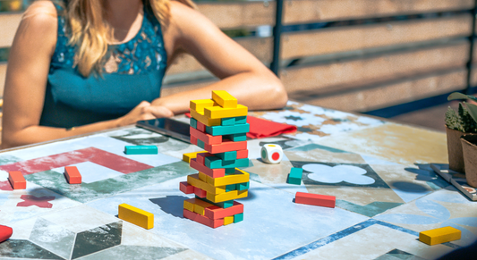Kidult e giochi da costruzione con un giocattolo impilabile colorato su un tavolo decorato.