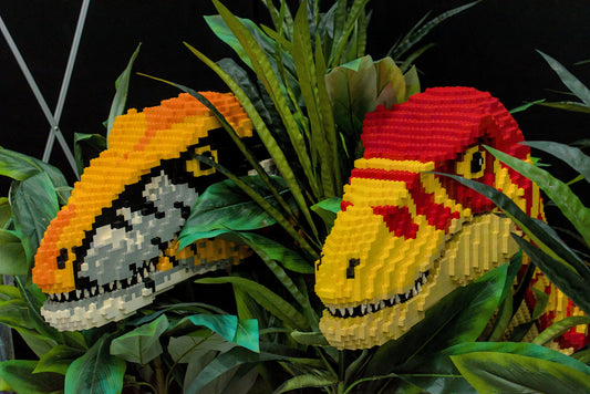 Due teste di dinosauri in mattoncini sfusi tra le piante, perfette per costruire MOC creativi