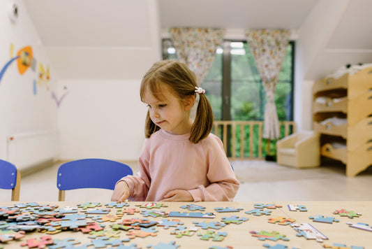 Bambina che gioca con puzzle, sviluppando il problem solving attraverso il gioco educativo.